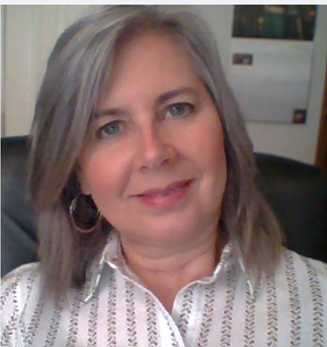 Smiling woman with gray hair and hoop earrings.
